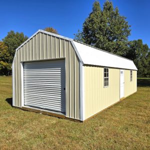 A spacious Premier Lofted Garage featuring Sandstone Metal siding, a bright White Metal Roof, a large roll-up garage door, a side entry door, and windows, set on a green lawn under a clear sky.