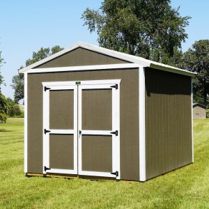 A newly installed Premier Utility shed featuring Driftwood siding and a Light Stone roof, with open double wooden doors revealing its spacious interior, set on a vibrant green lawn under a clear blue sky.