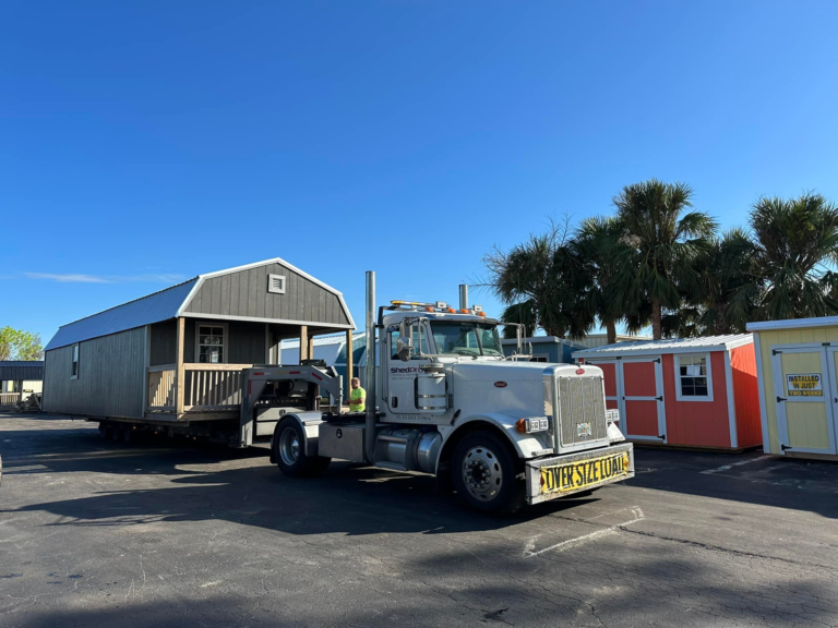 Premier Portable Buildings delivery truck Semi truck with loaded trailer hauling a Premier Lofted Barn Cabin.