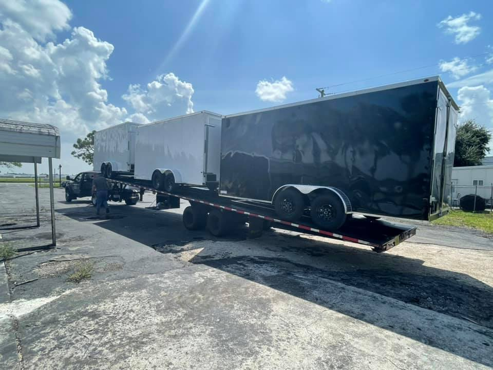 Trailer by Premier Delivery Truck hauling enclosed trailers.